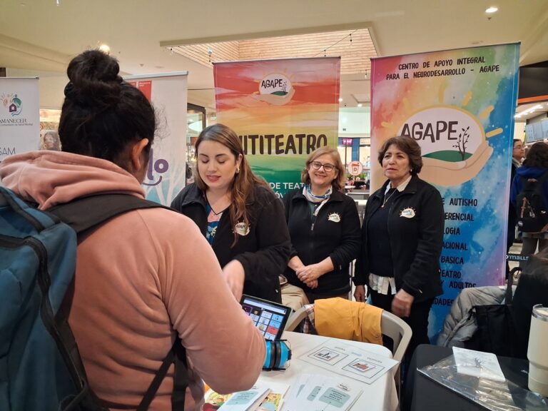 Equipo de Centro Ágape en su stand de la feria de concienciación sobre autismo en CENCO Temuco, junto a los banners de Ágape y Autiteatro.